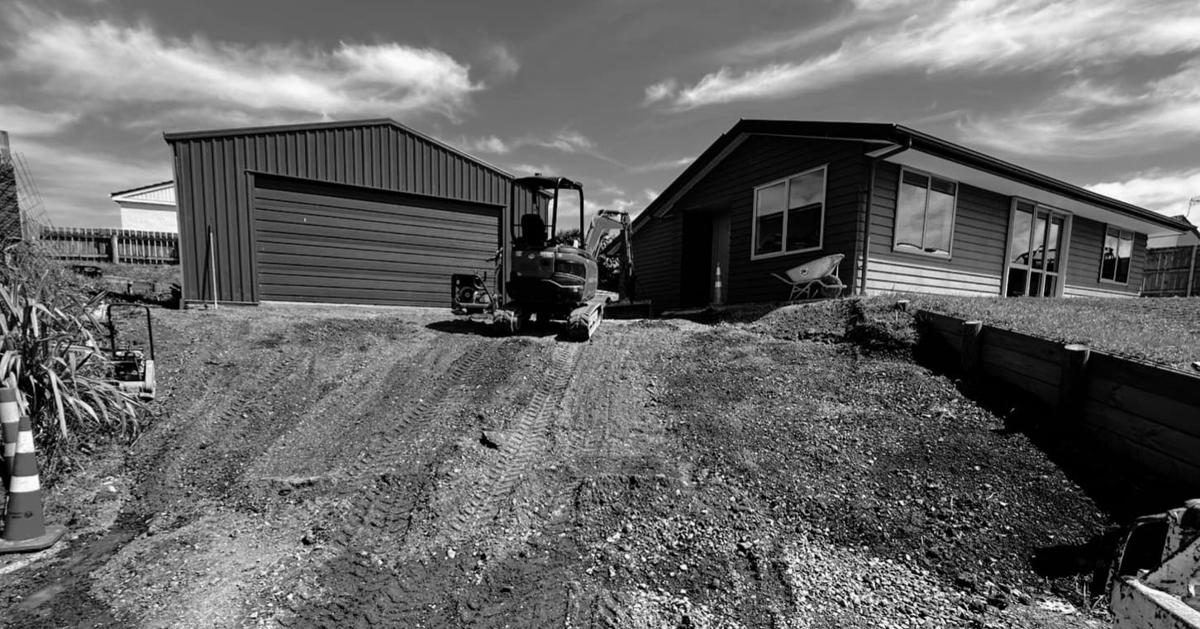 Before: bare, rutted clay in front of the same garage and house